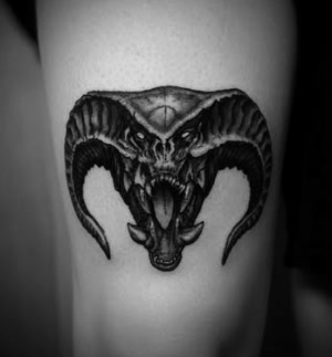 Black and grey demonic creature head tattoo