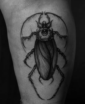Black and grey beetle with eye tattoo